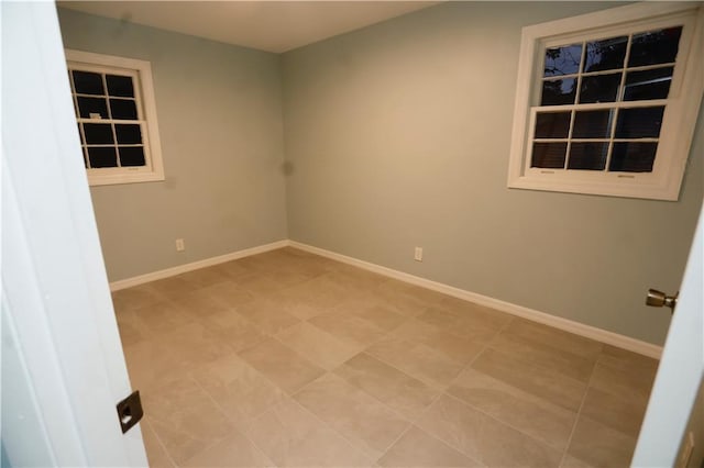 unfurnished room with baseboards