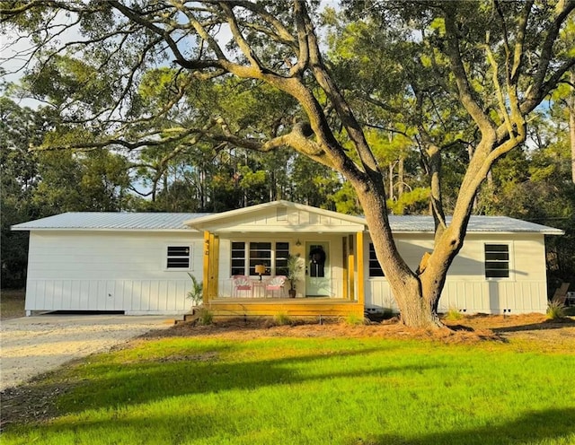 single story home featuring a porch and a front lawn