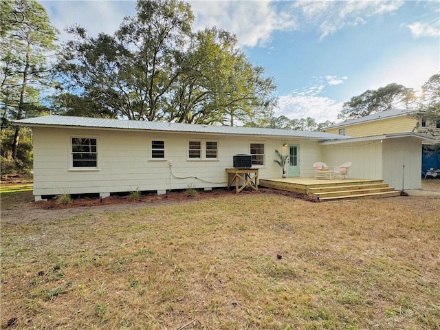 back of property featuring a wooden deck, a yard, and central AC