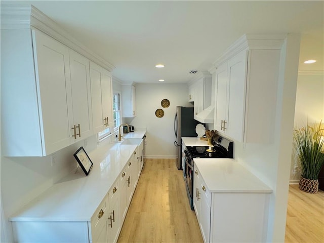 kitchen featuring light hardwood / wood-style flooring, white cabinets, and stainless steel range with electric stovetop