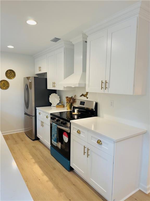 kitchen with white cabinets, stainless steel appliances, light hardwood / wood-style floors, and wall chimney exhaust hood