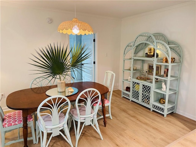 dining space featuring ornamental molding and hardwood / wood-style floors