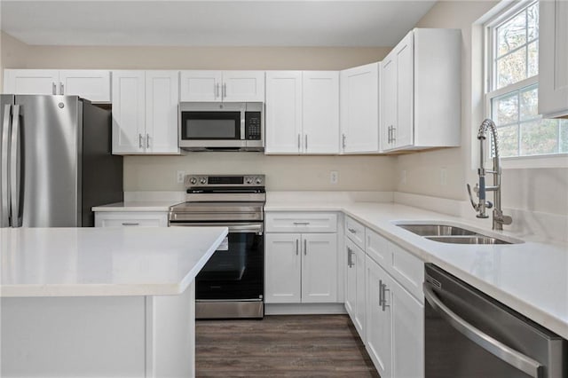 kitchen with white cabinetry, appliances with stainless steel finishes, sink, and dark hardwood / wood-style flooring