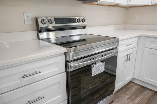 kitchen featuring white cabinets, dark hardwood / wood-style floors, and electric range