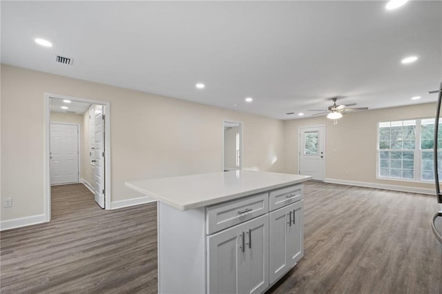 kitchen featuring dark hardwood / wood-style floors, ceiling fan, and a kitchen island