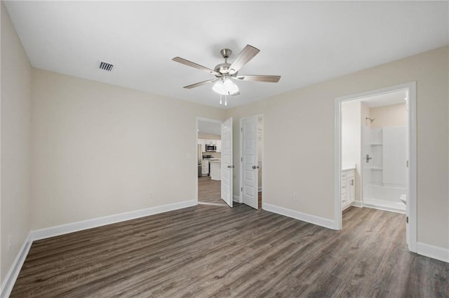 unfurnished bedroom featuring ceiling fan, ensuite bathroom, and dark hardwood / wood-style floors