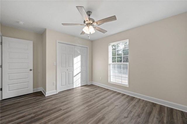 unfurnished bedroom with ceiling fan, dark hardwood / wood-style flooring, and a closet