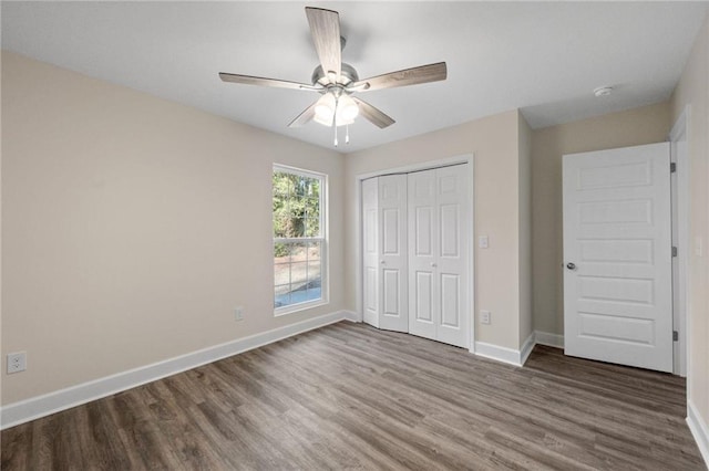 unfurnished bedroom featuring hardwood / wood-style flooring, ceiling fan, and a closet