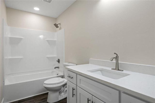 full bathroom featuring vanity, hardwood / wood-style flooring, tub / shower combination, and toilet