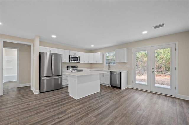 kitchen featuring white cabinetry, dark hardwood / wood-style flooring, a center island, stainless steel appliances, and french doors