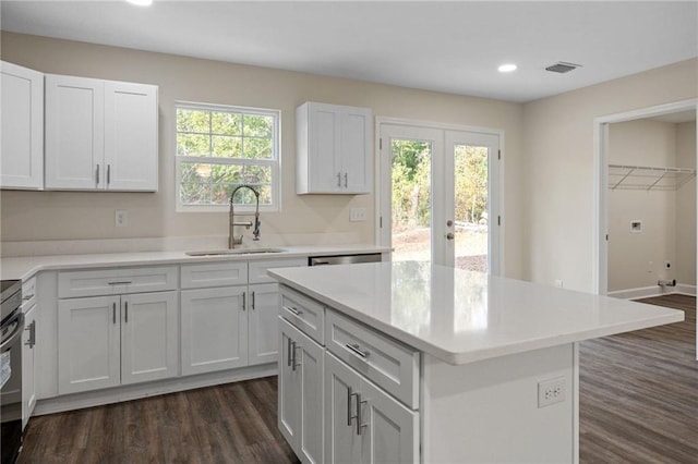 kitchen with white cabinetry, a healthy amount of sunlight, sink, and a kitchen island