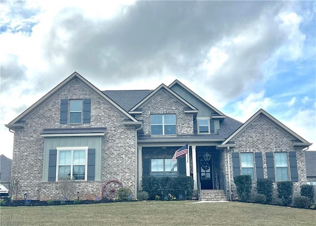 craftsman-style home featuring a front lawn, board and batten siding, and brick siding