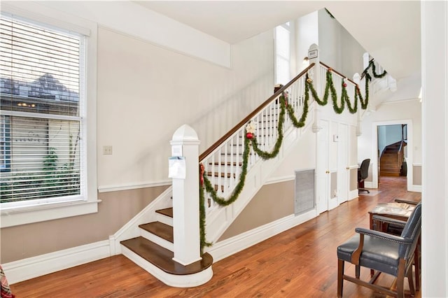 stairs featuring hardwood / wood-style flooring and a healthy amount of sunlight