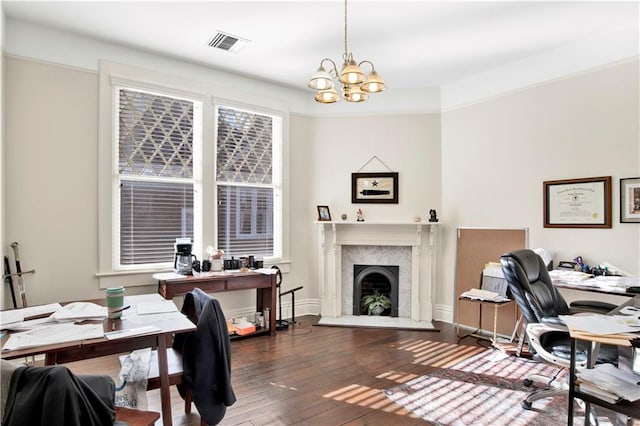 office area featuring a notable chandelier, a fireplace, and dark wood-type flooring