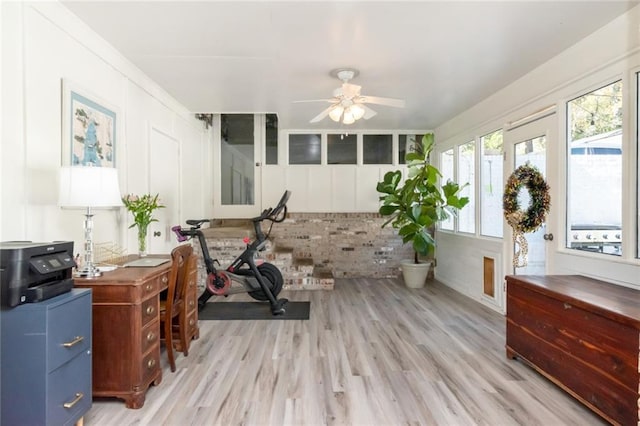 workout room featuring ceiling fan and light hardwood / wood-style flooring