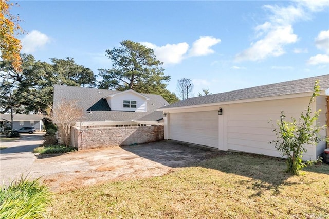 view of side of home with a yard and a garage