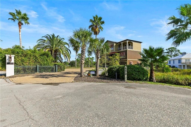 exterior space with decorative driveway and fence