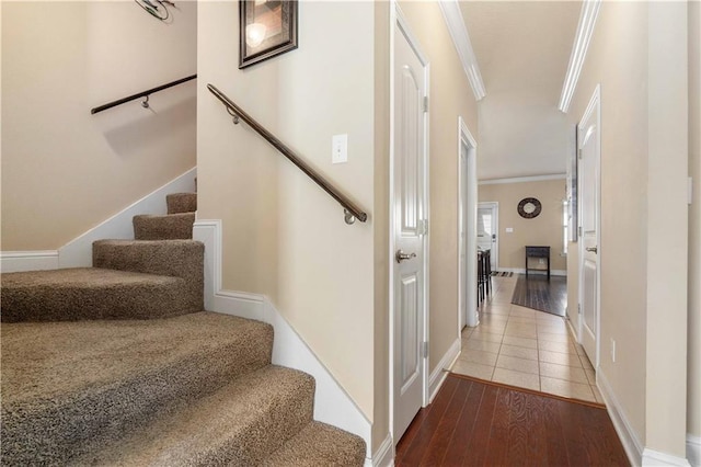 staircase with baseboards, wood finished floors, and crown molding