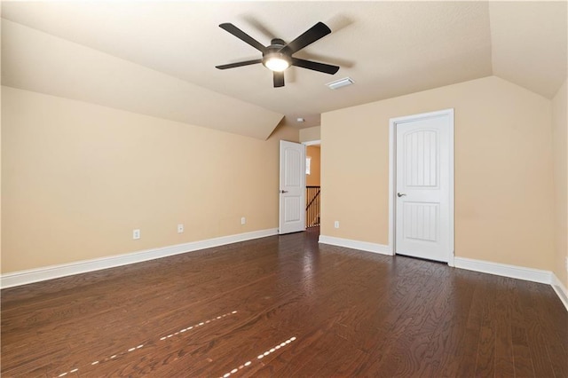 bonus room with dark wood finished floors, lofted ceiling, visible vents, a ceiling fan, and baseboards