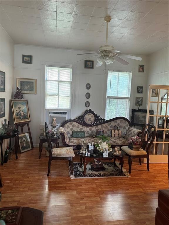 living room with ceiling fan, a wealth of natural light, hardwood / wood-style flooring, and a fireplace