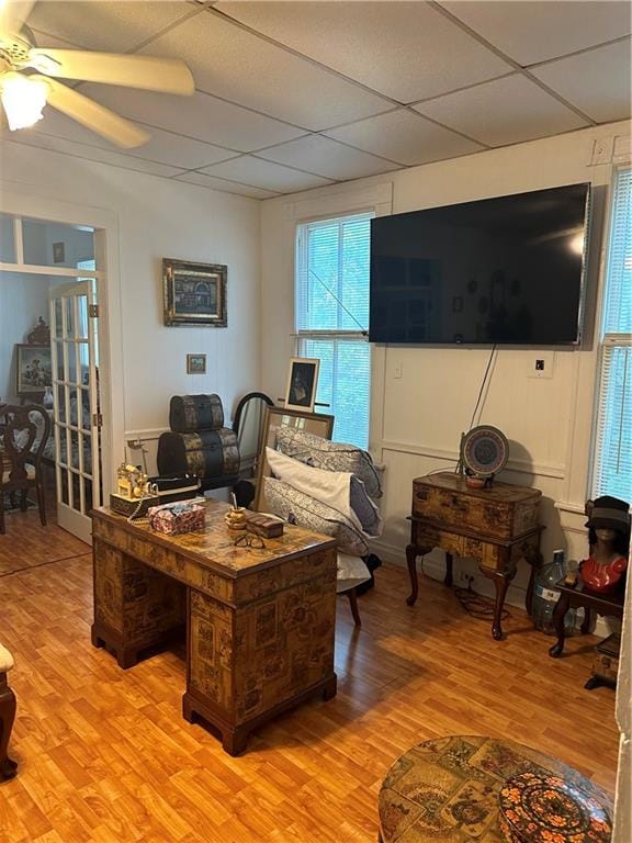 living room with a paneled ceiling, ceiling fan, and wood-type flooring