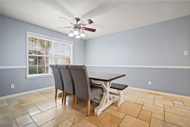 dining area featuring ceiling fan and a textured ceiling