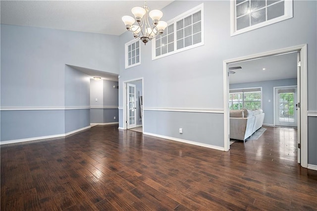 interior space with high vaulted ceiling, an inviting chandelier, and dark hardwood / wood-style floors