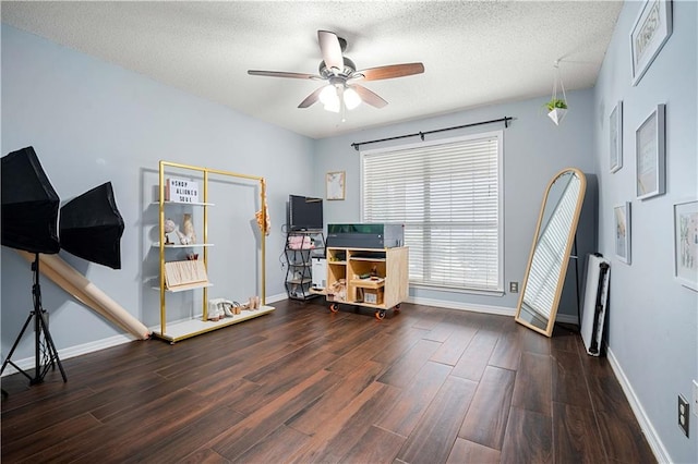 office space featuring dark wood-type flooring, ceiling fan, and a textured ceiling