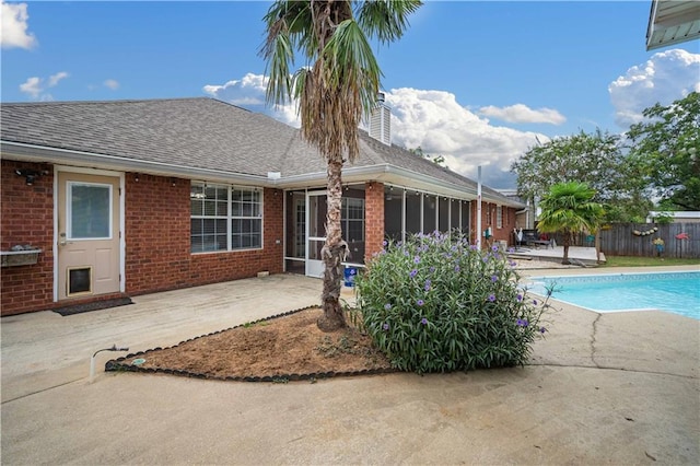 view of pool with a patio and a sunroom