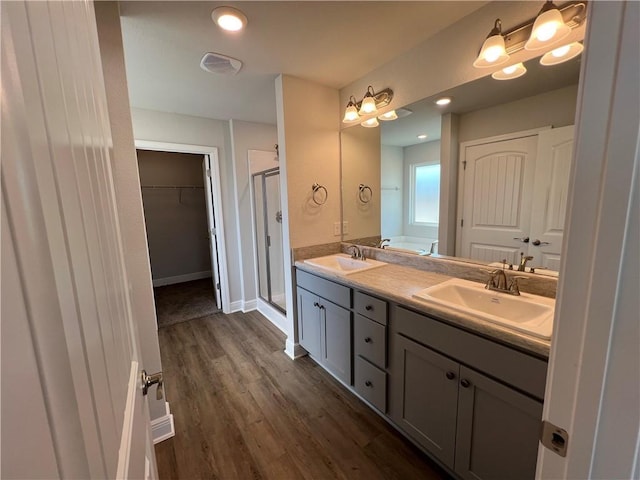 bathroom featuring vanity, a shower with door, and wood-type flooring