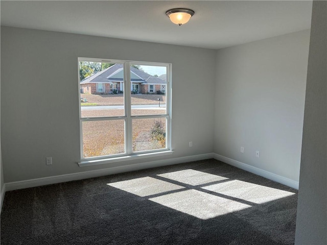 unfurnished room featuring dark carpet