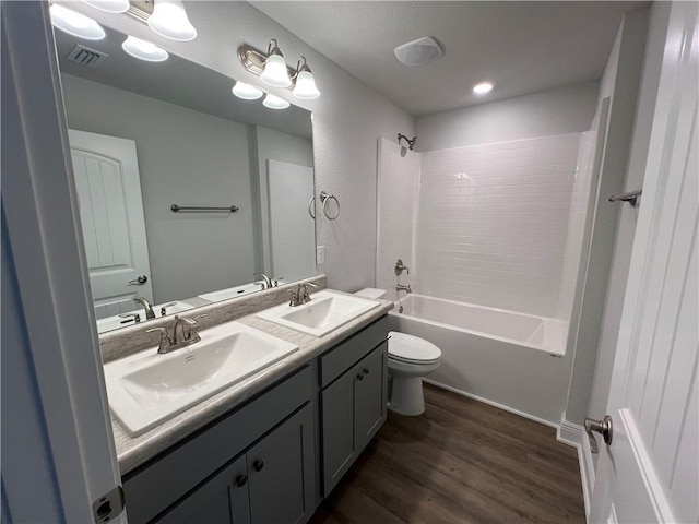 full bathroom featuring hardwood / wood-style flooring, shower / tub combination, toilet, and vanity