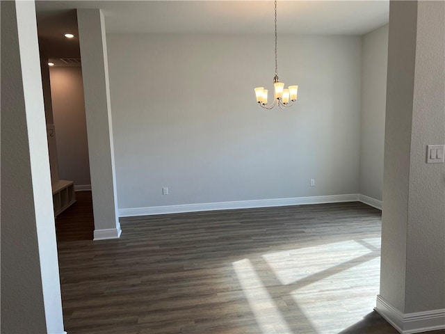 unfurnished room featuring an inviting chandelier and dark hardwood / wood-style floors