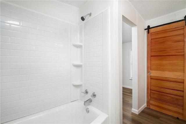 full bath with bathtub / shower combination, a textured ceiling, baseboards, and wood finished floors