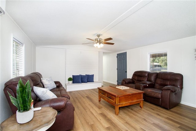 living room with vaulted ceiling, ceiling fan, and light wood-type flooring