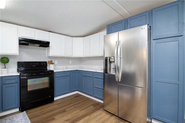 kitchen with blue cabinetry, light countertops, black range with electric stovetop, under cabinet range hood, and stainless steel fridge with ice dispenser