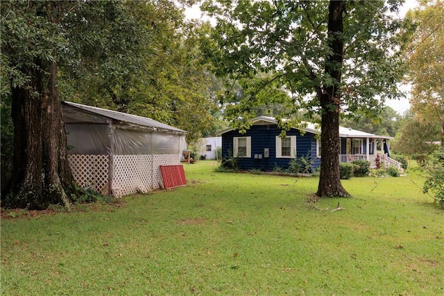 view of yard featuring a porch and an outdoor structure