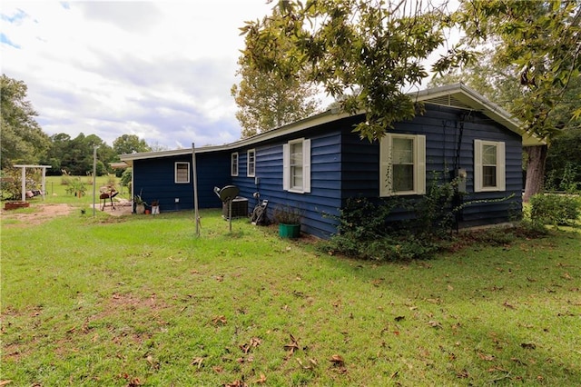 back of house featuring a yard and cooling unit