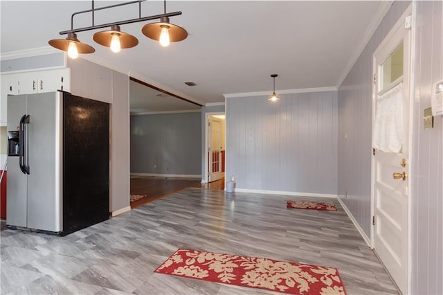 interior space with white cabinetry, ornamental molding, visible vents, wood finished floors, and stainless steel fridge