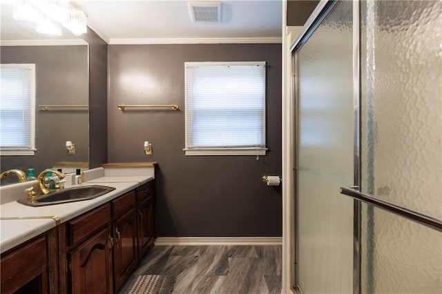 bathroom featuring vanity, ornamental molding, visible vents, wood finished floors, and baseboards