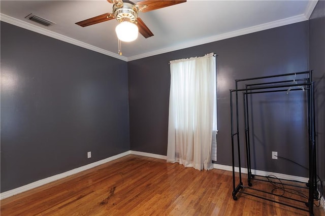 unfurnished bedroom featuring visible vents, baseboards, ornamental molding, ceiling fan, and wood finished floors