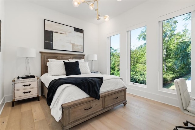 bedroom featuring an inviting chandelier and light wood-type flooring