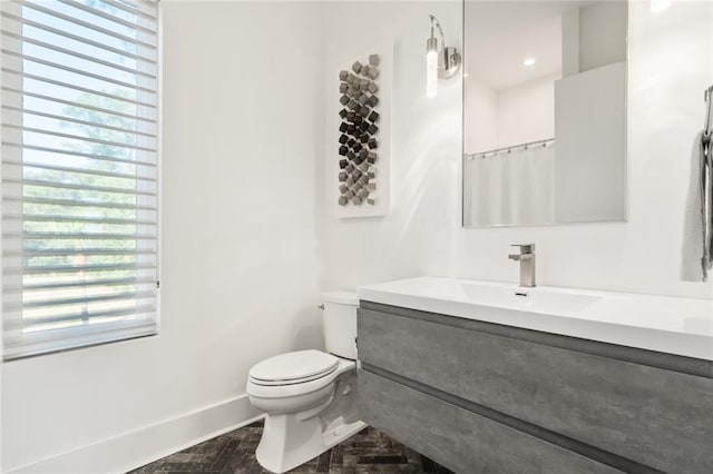 bathroom featuring vanity, curtained shower, and toilet