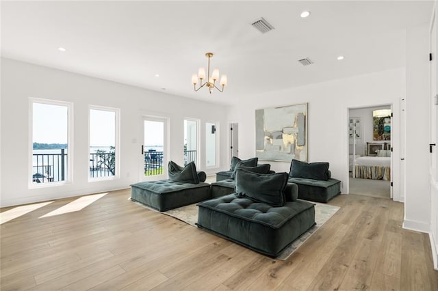 living room featuring an inviting chandelier and light wood-type flooring