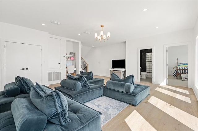 living room with an inviting chandelier and light hardwood / wood-style floors