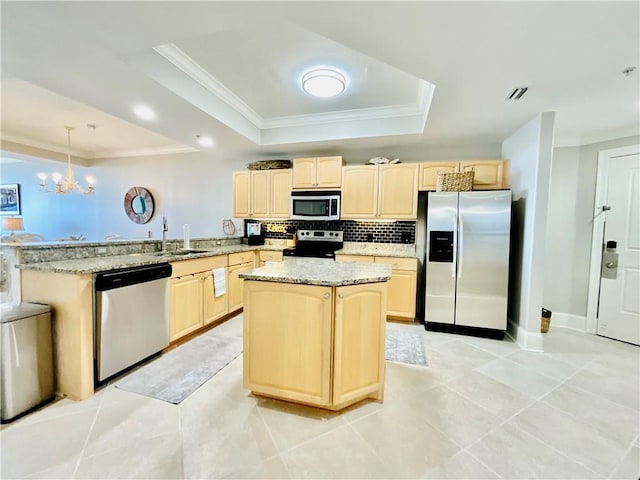 1601 Bienville Blvd Unit 316, Dauphin Island, AL 36528 - kitchen featuring light brown cabinets, a peninsula, a raised ceiling, stainless steel appliances, and a sink