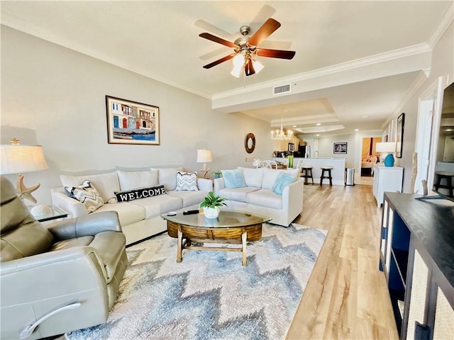 1601 Bienville Blvd Unit 316, Dauphin Island, AL 36528 - living room with light wood-style flooring, ceiling fan with notable chandelier, ornamental molding, and visible vents