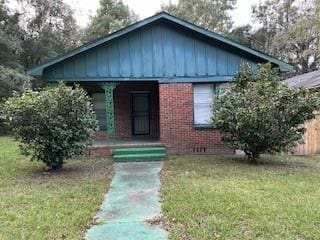 bungalow-style house featuring covered porch and a front yard