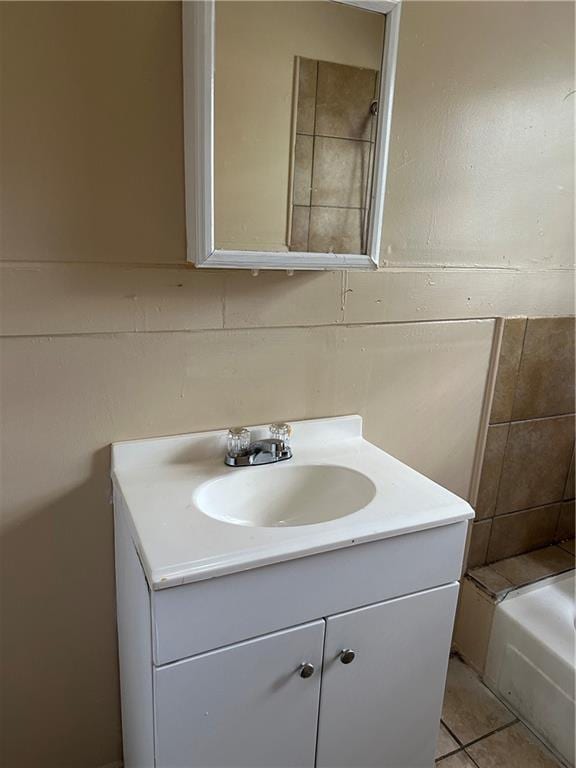 bathroom with tile patterned floors, vanity, and a washtub