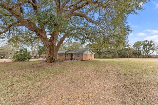 view of front of home with a front lawn and brick siding